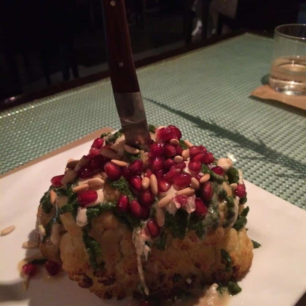 Cauliflower with tahini sauce, chilli and coriander salsa, pomegranate seeds and pine nuts