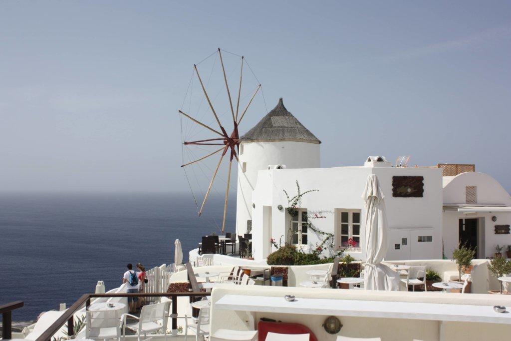 Windmill and whitewashed buildings overlooking the sea in Greece