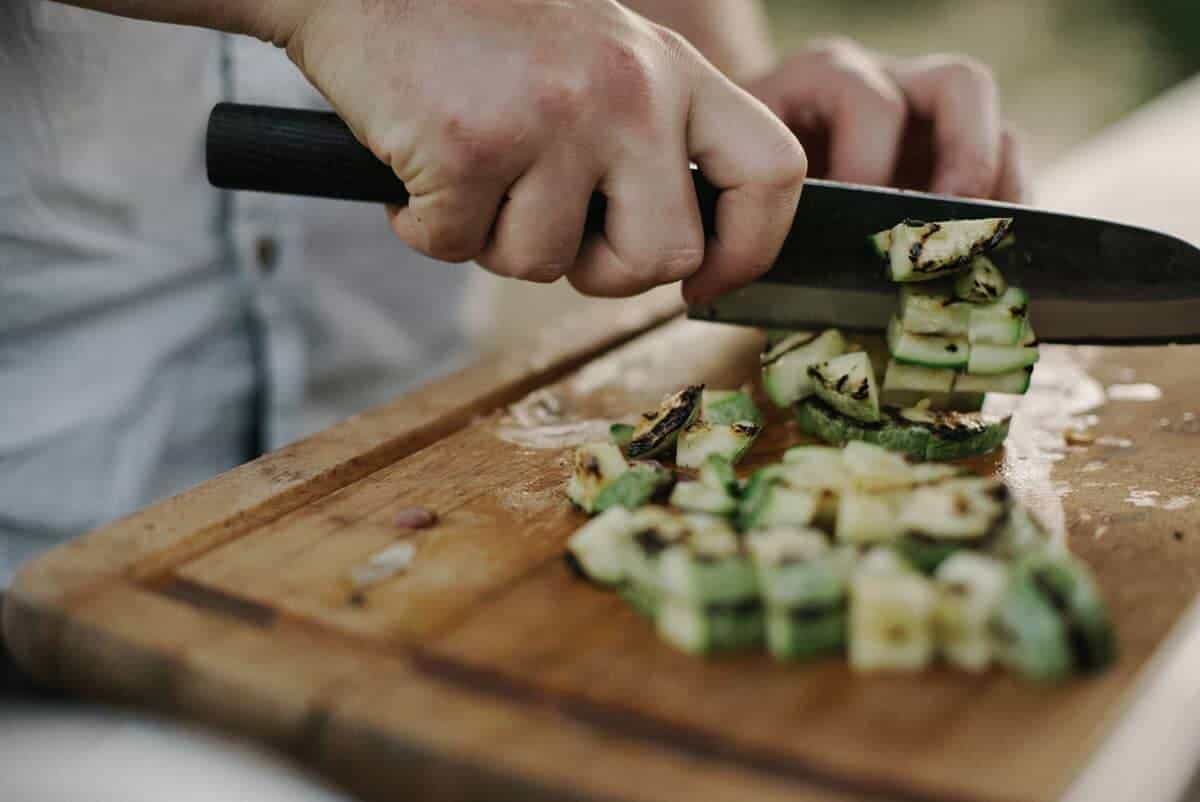 Hand chopping zucchini. The best vegan cooking classes online and in person