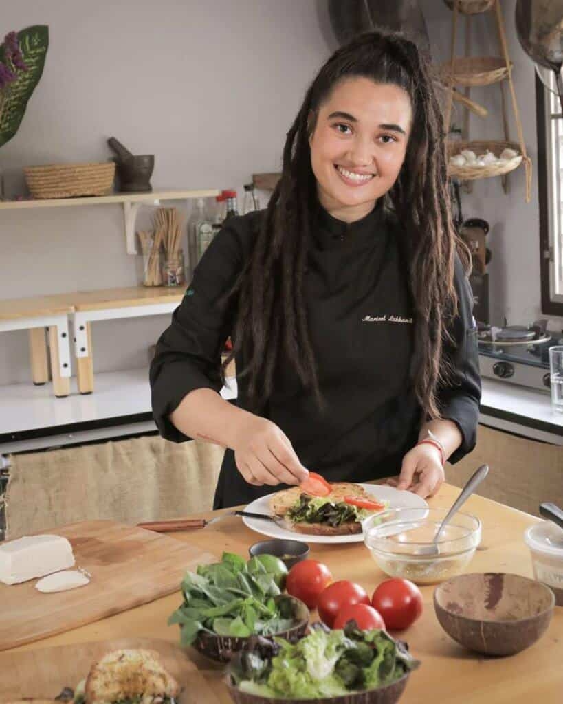 Chef preparing meal with vegetables on table