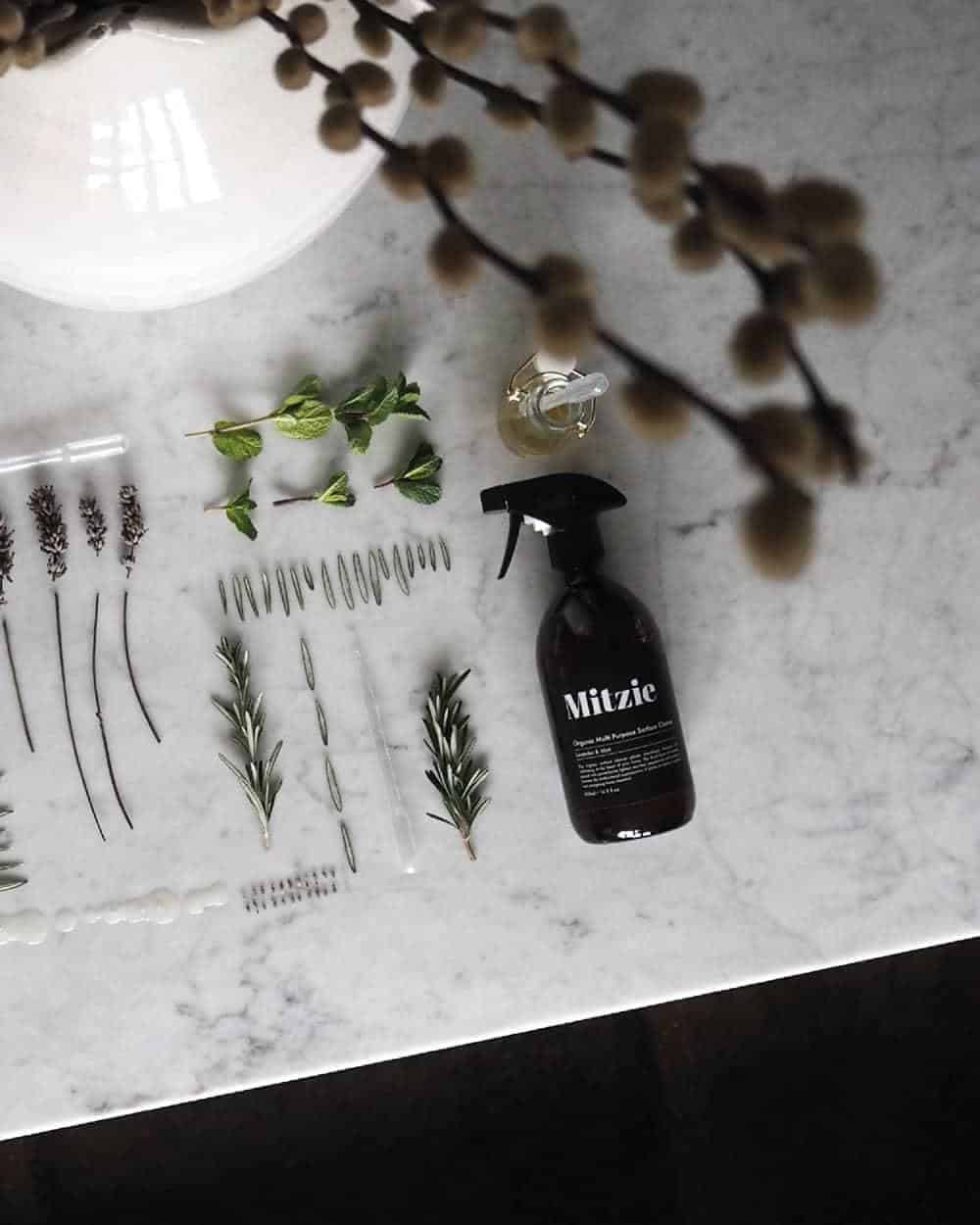 A cleaning spray bottle and dried herbs