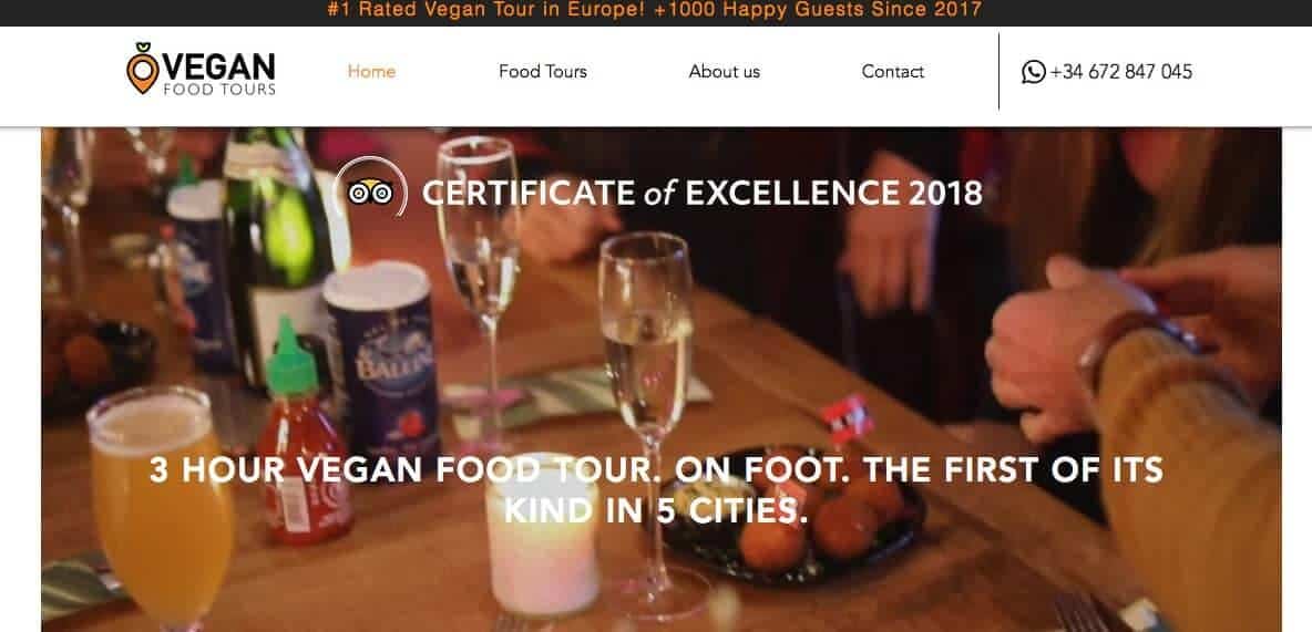 Screenshot of Vegan Food Tours showing glasses of champagne, glass of beer and food on a bar table