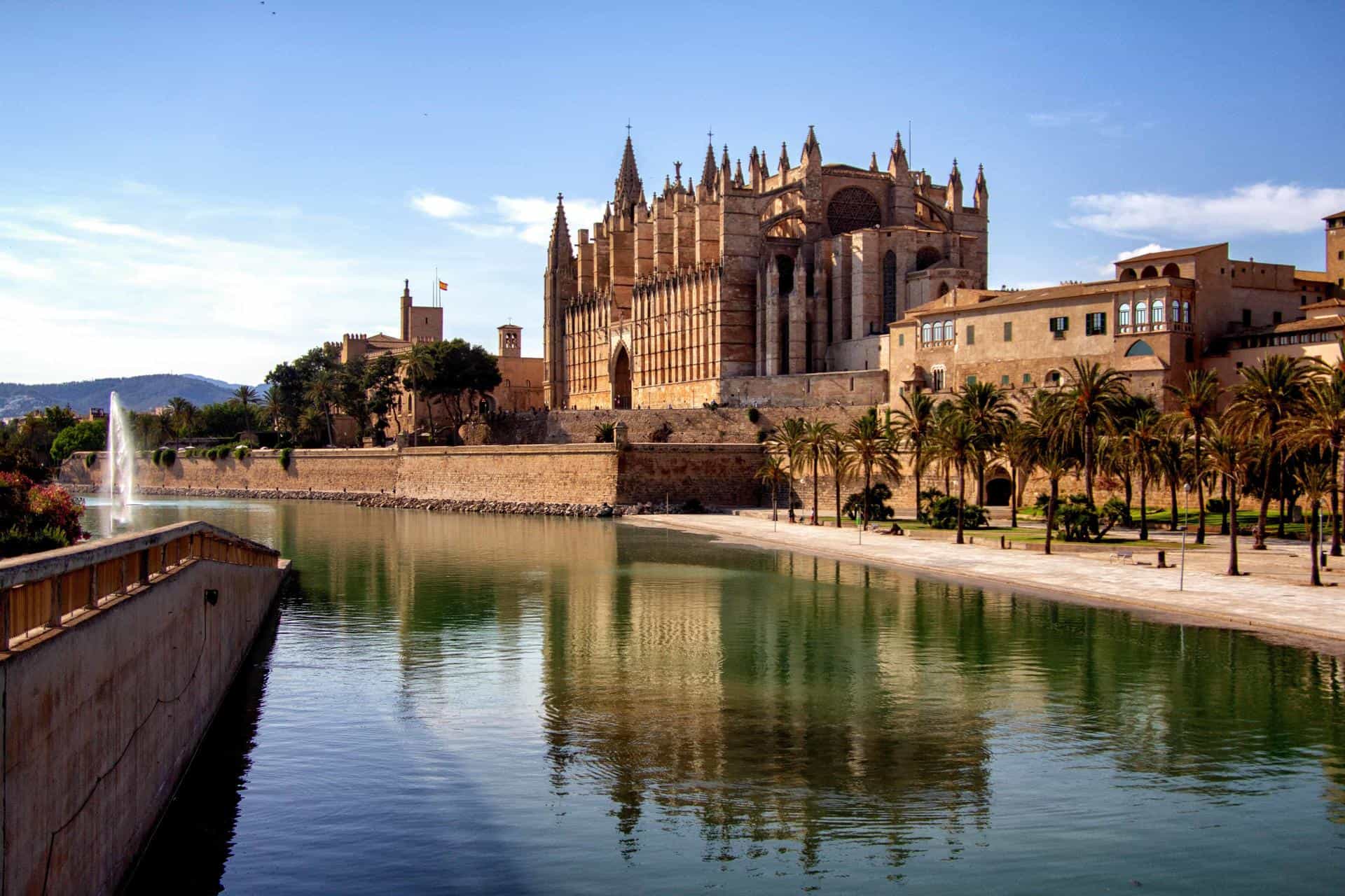 Cathedral reflected in water, with mountains in the background