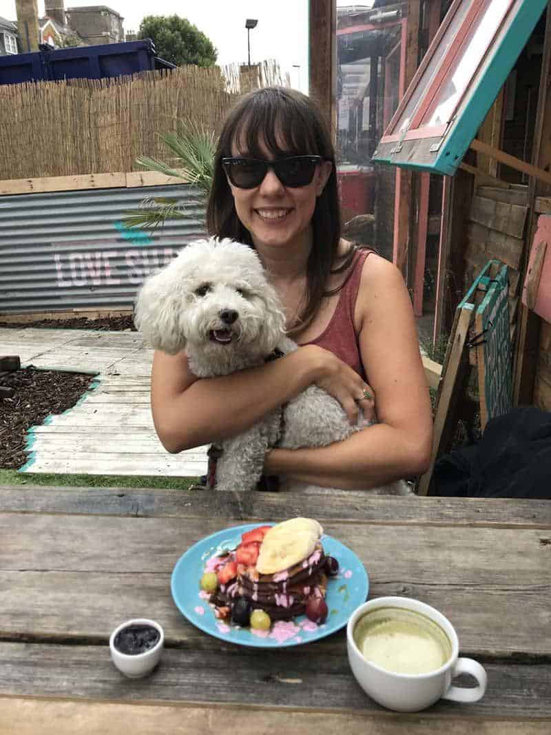 The author, Caitlin Galer-Unti, pictured with her dog, Benito, at a vegan restaurant in London, Love Shack