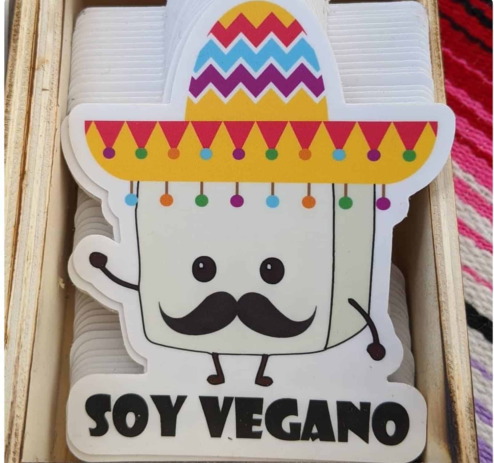 Pin of a cartoon tofu with a moustache that says "soy vegano"