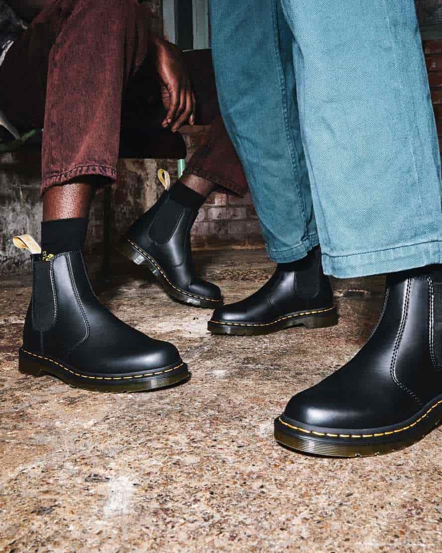 Two pairs of feet wearing doc marten vegan chelsea boots