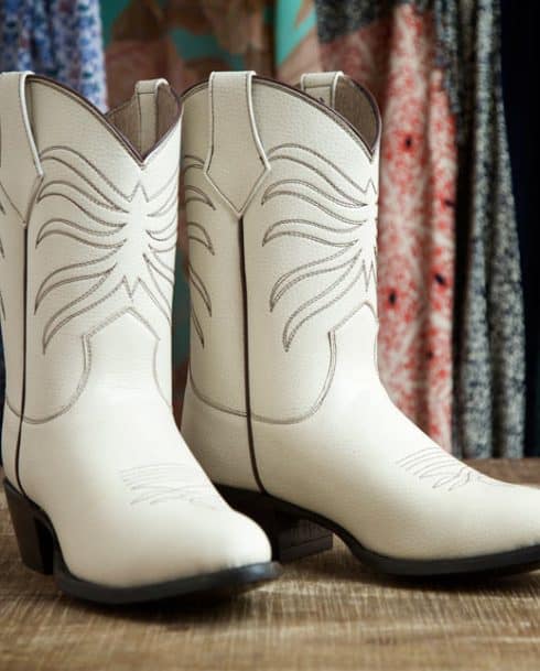 White vegan cowboy boots with decorative motif and low heel