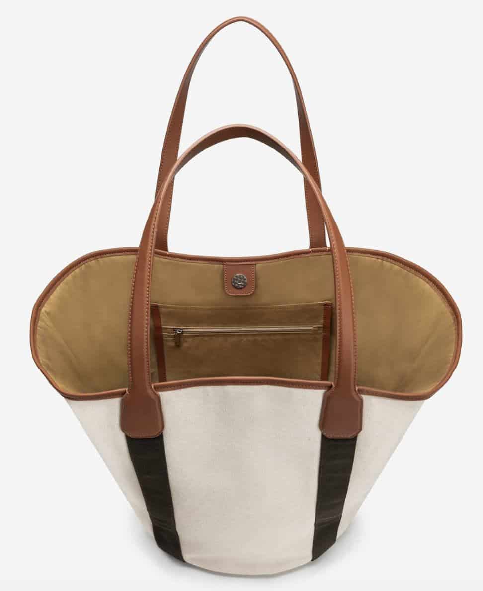 Beige canvas tote with brown vegan leather handles and trim and black vertical stripes from handles down to bottom of the bag