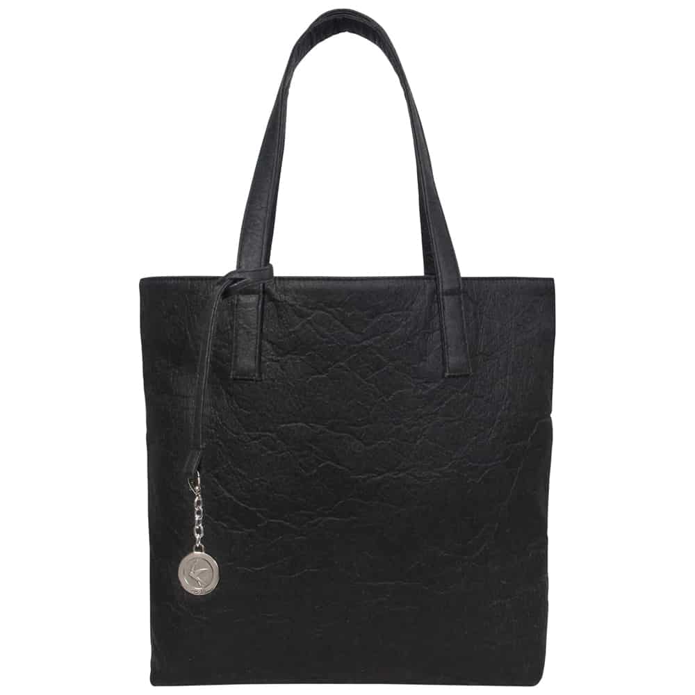 Textured vegan leather tote bag with silver stamp medal (stamped with Svala logo) hanging on chain from side of bag