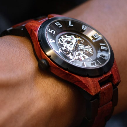 Picture of someone's wrist wearing Jord watch with wooden strap, black dial