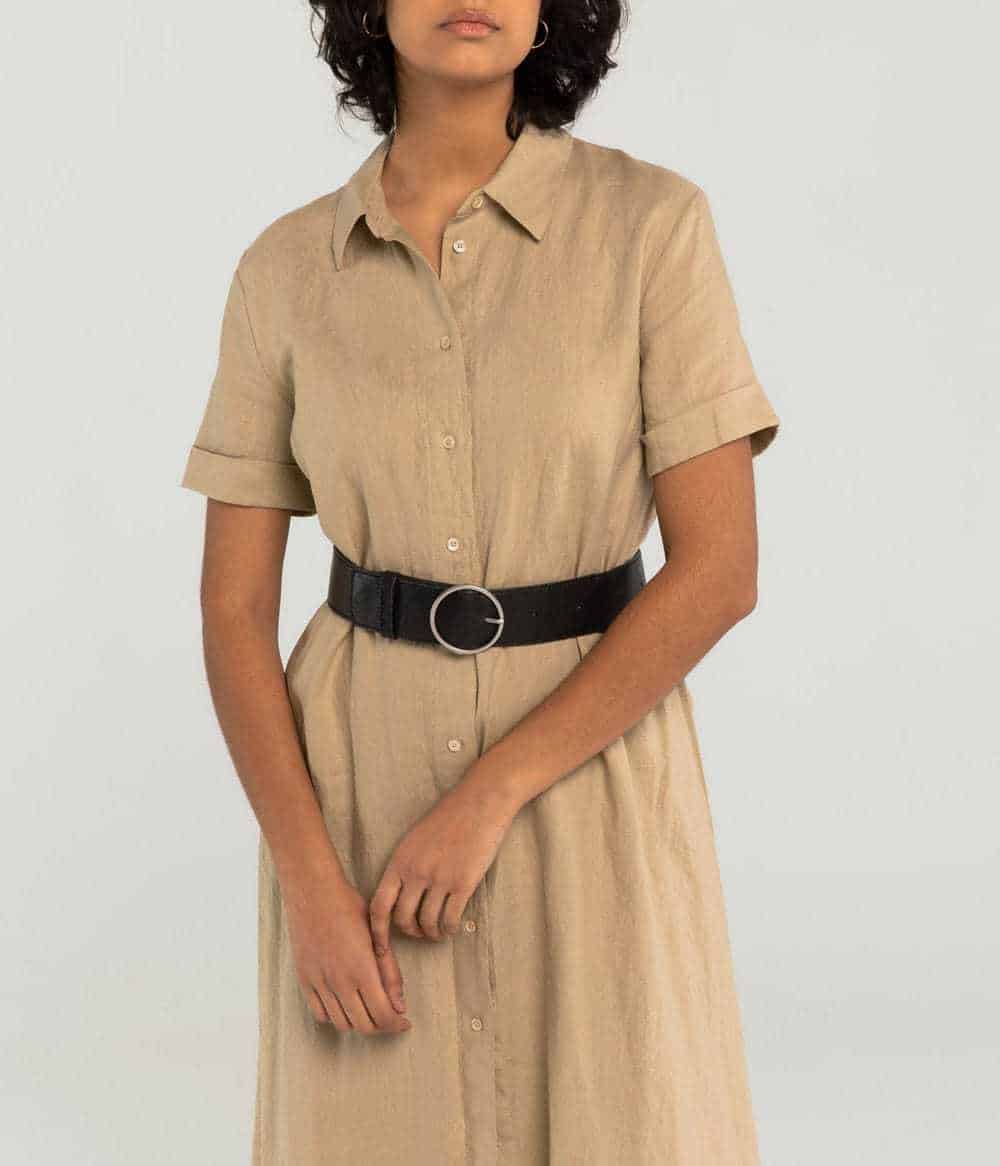 Person shown wearing belt vegan in brown with circular buckle with a tan dress
