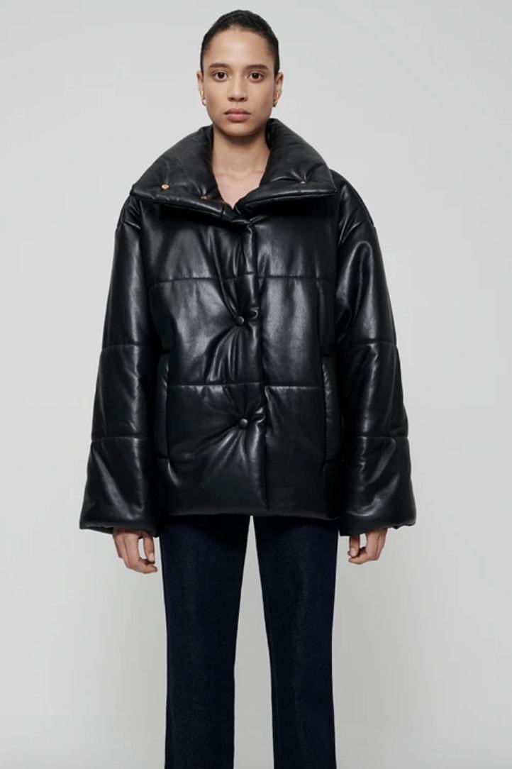 Person shown wearing black vegan leather puffer jacket