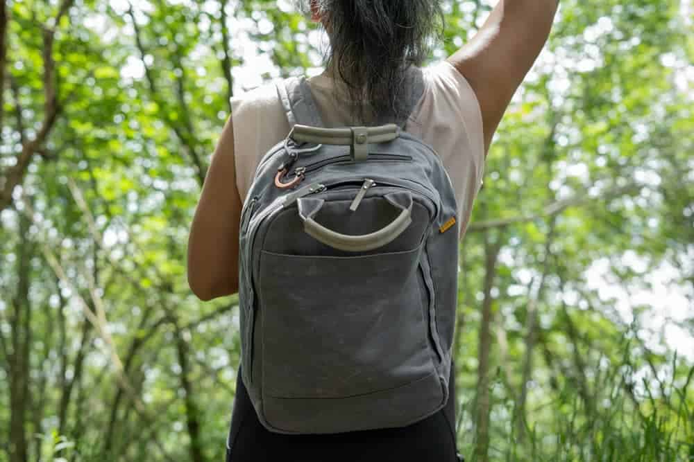 Person wearing grey laptop in a forest