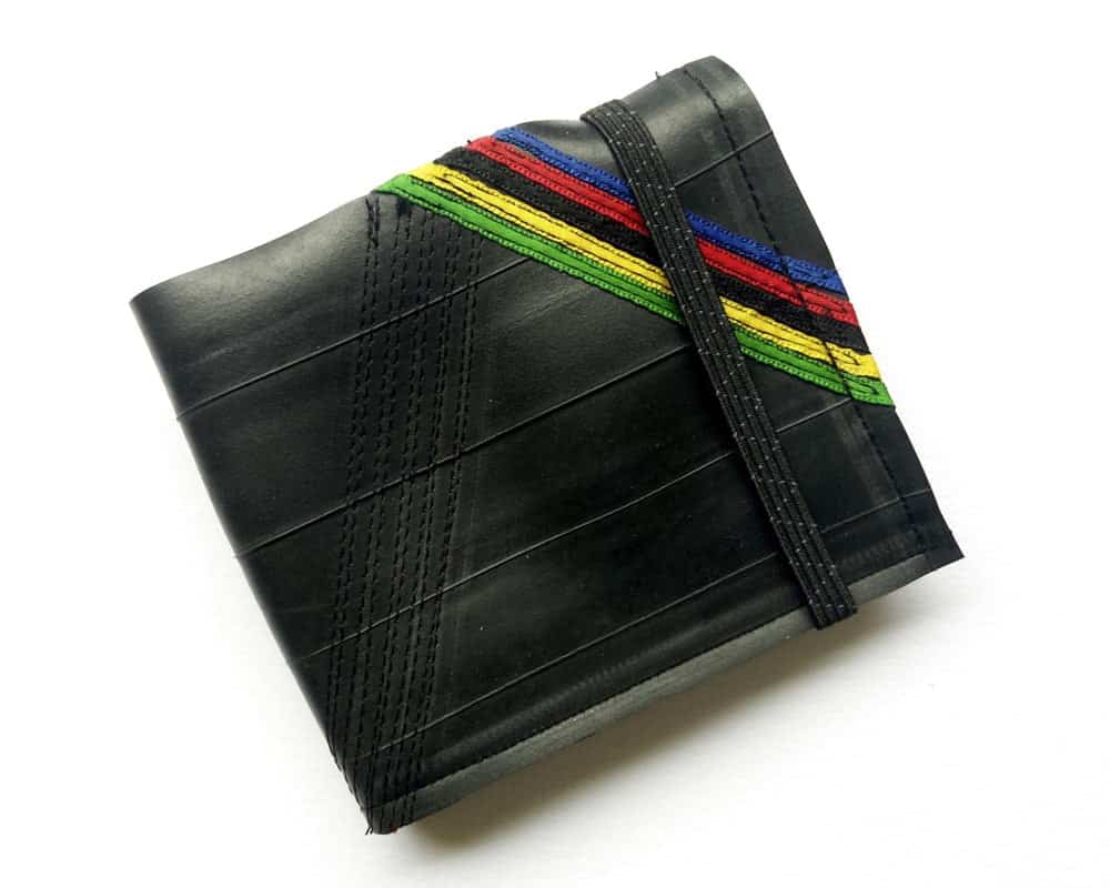 Black wallet with stripes in blue, red, black, yellow and green in the corner, with built in elastic to keep it closed