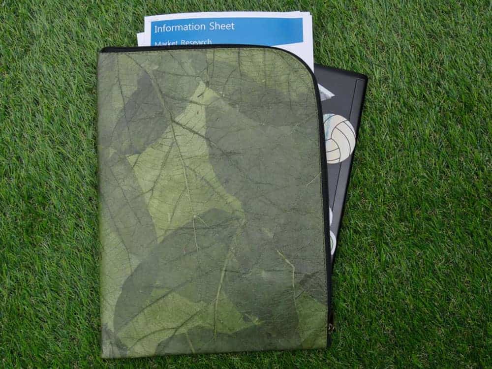 Green leaf leather laptop case with leaves visible in overlaid pattern