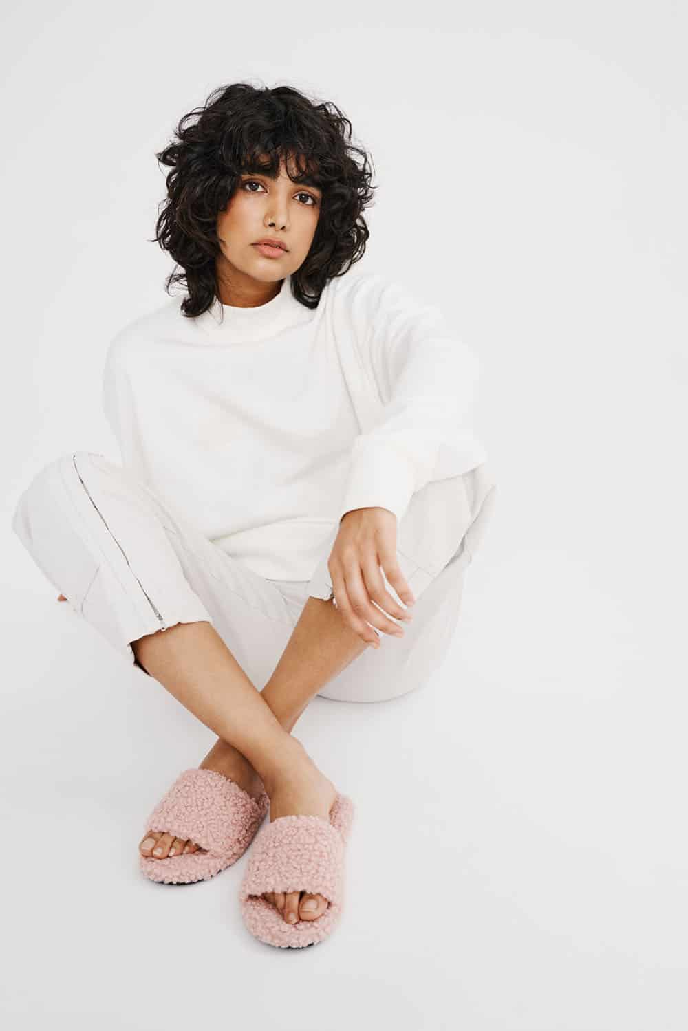 Woman wearing pink faux wool slide slippers