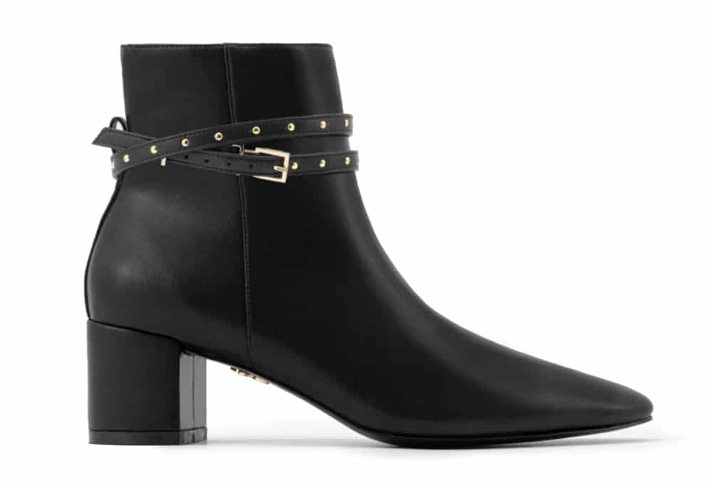 Black heeled vegan leather ankle boots with studded black strap on ankle