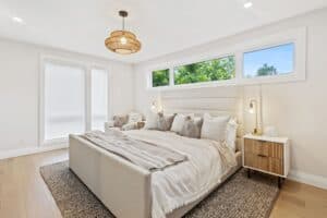 Bedroom with white covers and grey cushions on bed