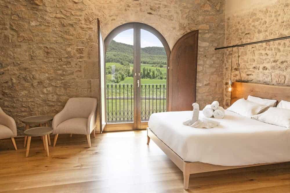 Room with exposed brickwork, seating area and view of surrounding countryside at Casa Albets