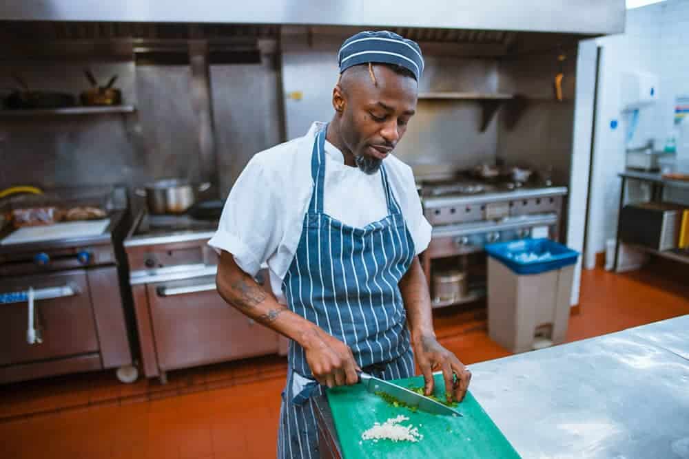 Chef chopping garlic and herbs