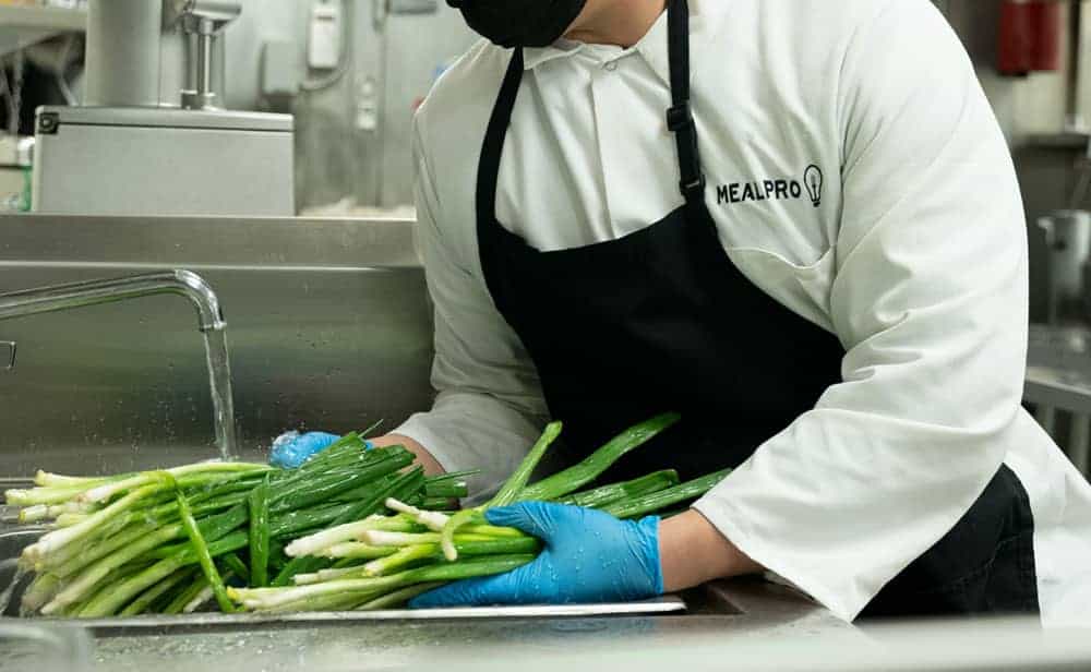 Chef washing spring onions