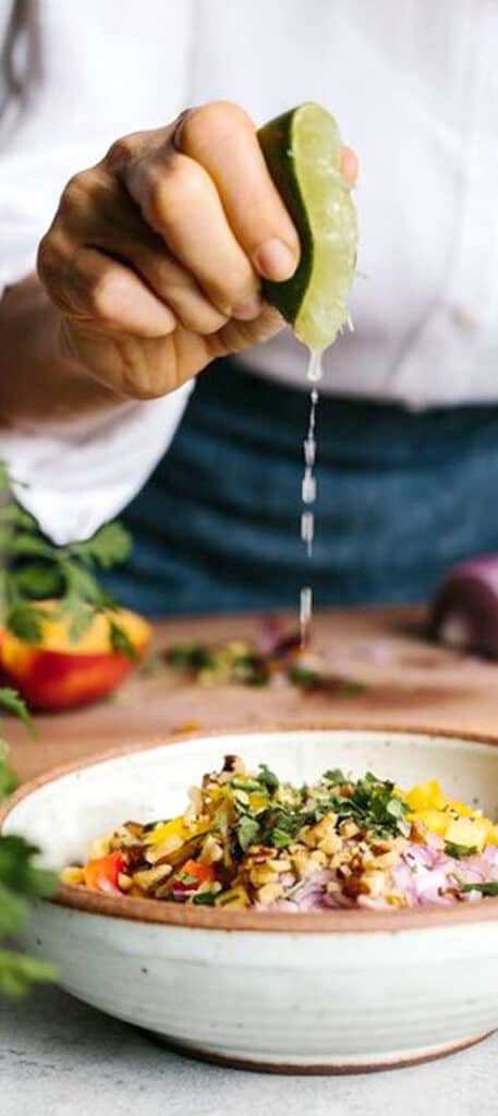 Chef squeezing lime over dish