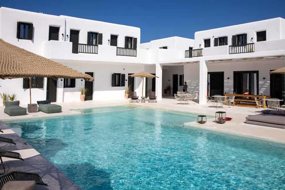 Whitewashed traditional Greek style buildings set around pool at Koukoumi Hotel