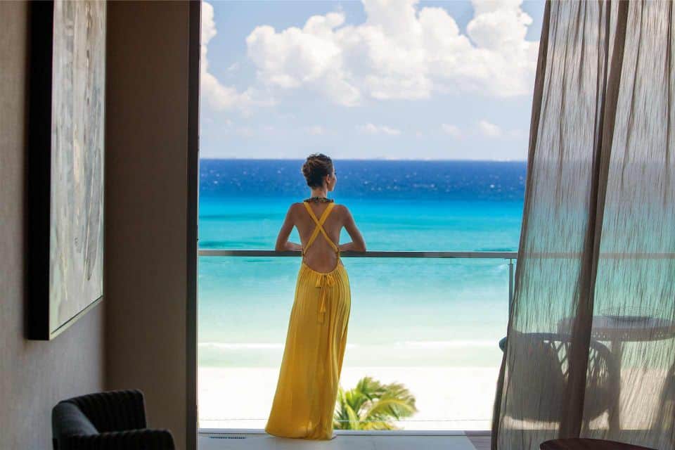 Person standing at railing looking out at Caribbean sea at Palmaia