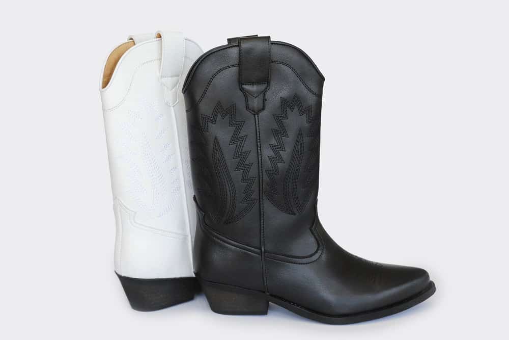 White vegan leather cowboy boot and black vegan leather cowboy boot