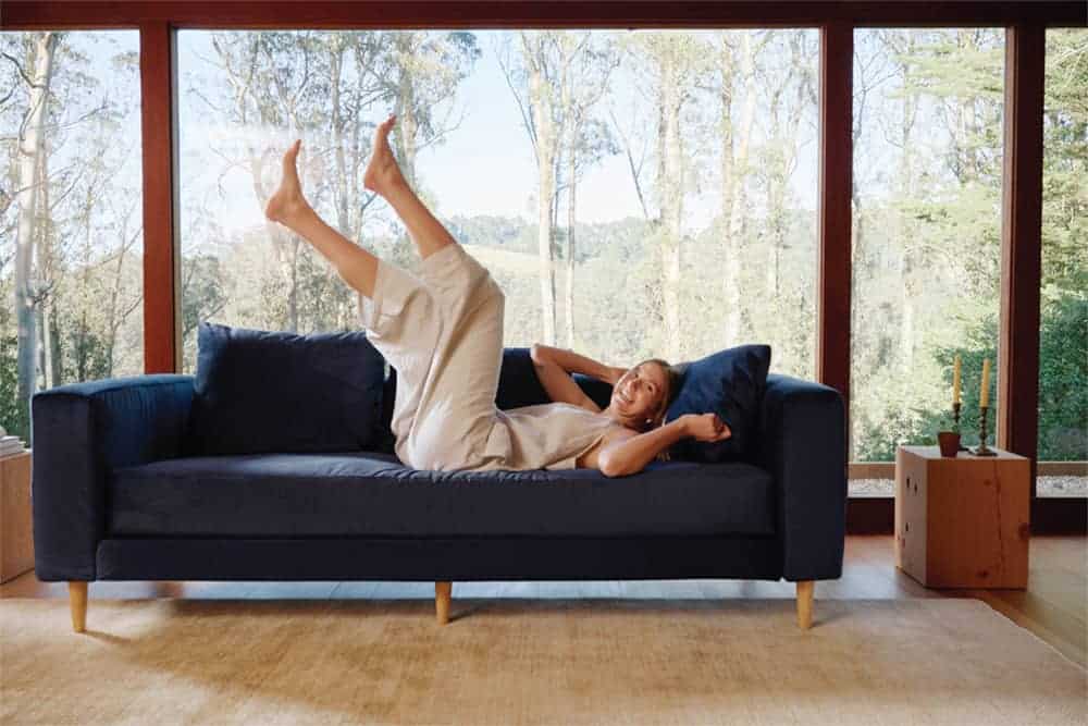 Person jumping on blue velvet Sabai sofa