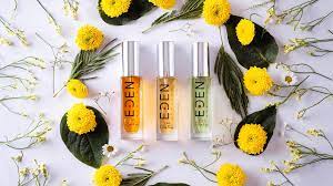 Three bottles of Eden vegan perfumes surrounded by flowers