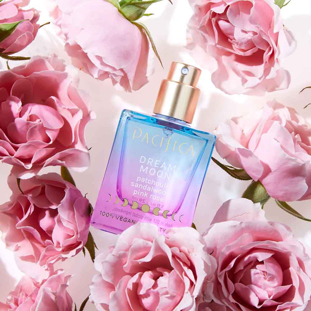 Pacifica vegan perfume, bottle is blue and pink and surrounded by roses