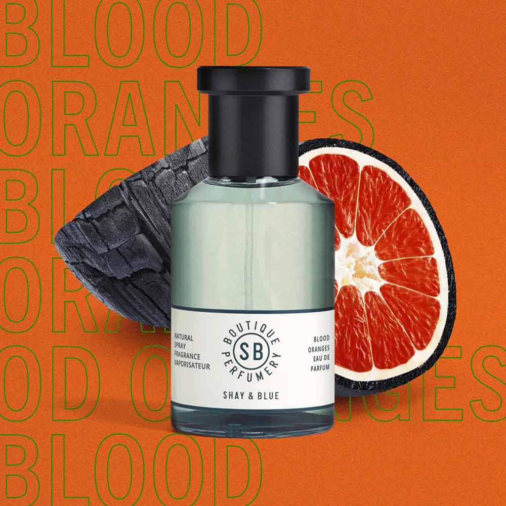 Shay and Blue perfume bottle with blood orange in the background and text that reads "blood orange" on oragne background