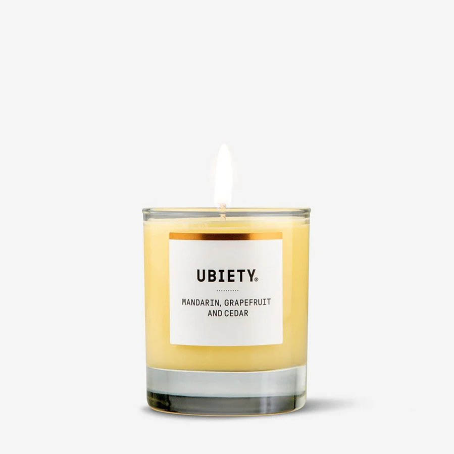 Ubiety candle, lit up in mandarin, cedar and grapefruit scent