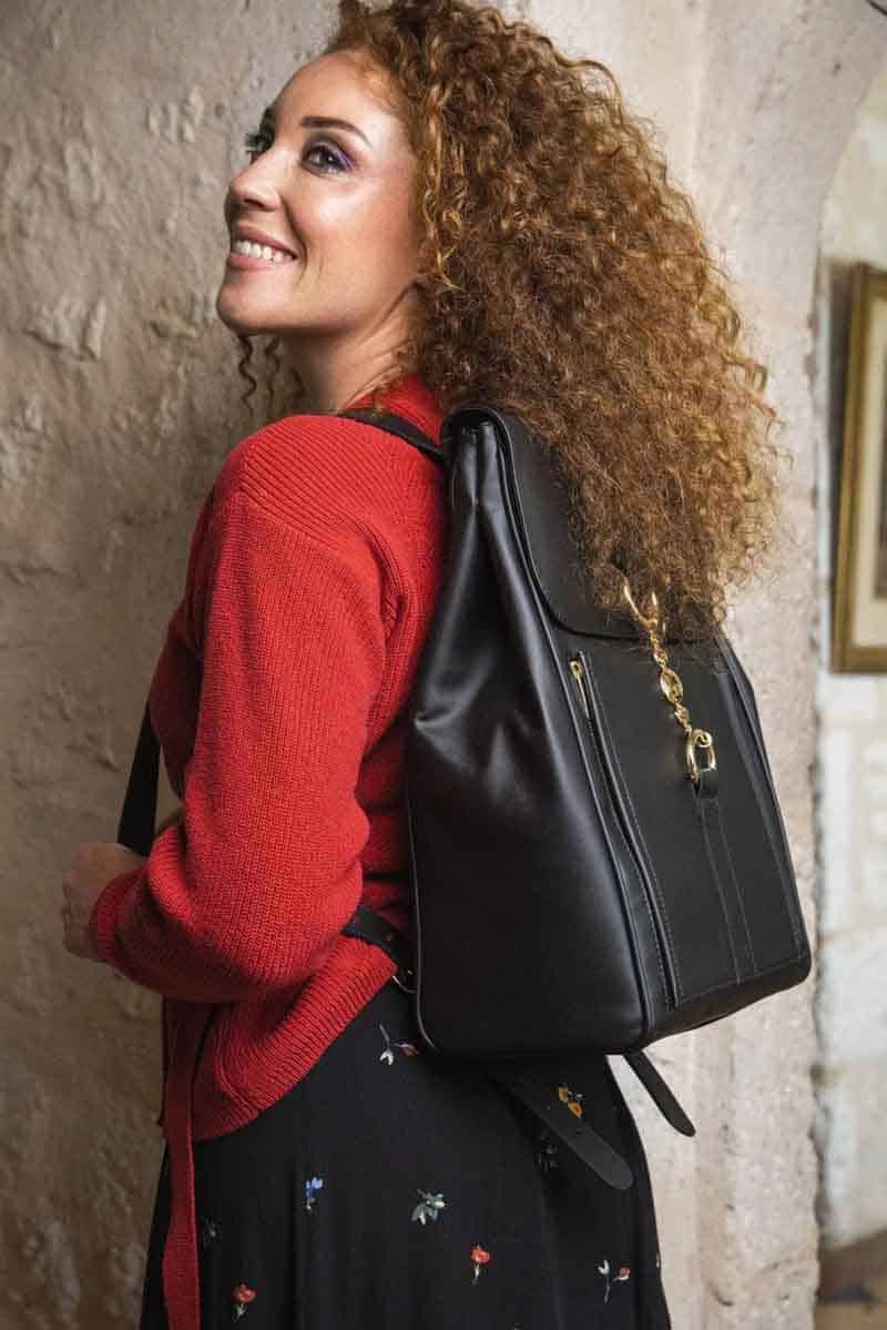 Woman in red top carrying black vegan leather backpack from Minuit Sur Terre