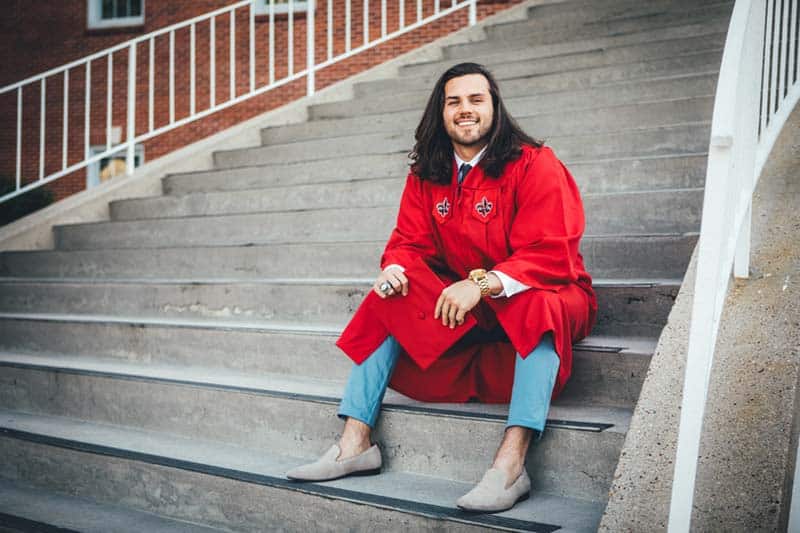 Man wearing grey loafers and graduation gown