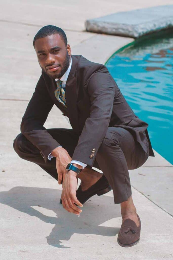 Man crouching down, wearing suit and loafers