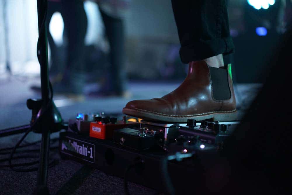 Person wearing Chelsea boots using music equipment with foot