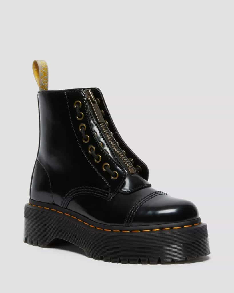 Vegan patent black leather Dr Martens sinclair platform boots. They have a zipper down the middle and eyelets (but no laces), traditional Doc Marten yellow stitching and a yellow pull tab