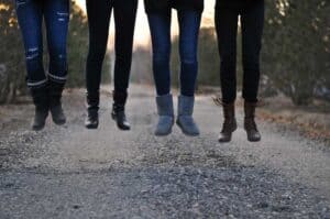 Four people jumping off ground wearing ugg boots