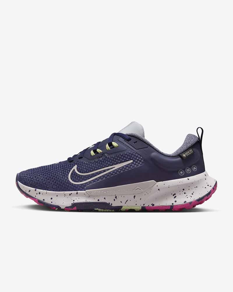 Nike leather free trail running shoes for women, dark purple upper with white outline Nike logo, white speckled heels, sole with bright green and purple