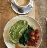 Vegan breakfast (avocado toast, spinach, cooked tomatoes, coffee) at a cafe in Amsterdam, Netherlands